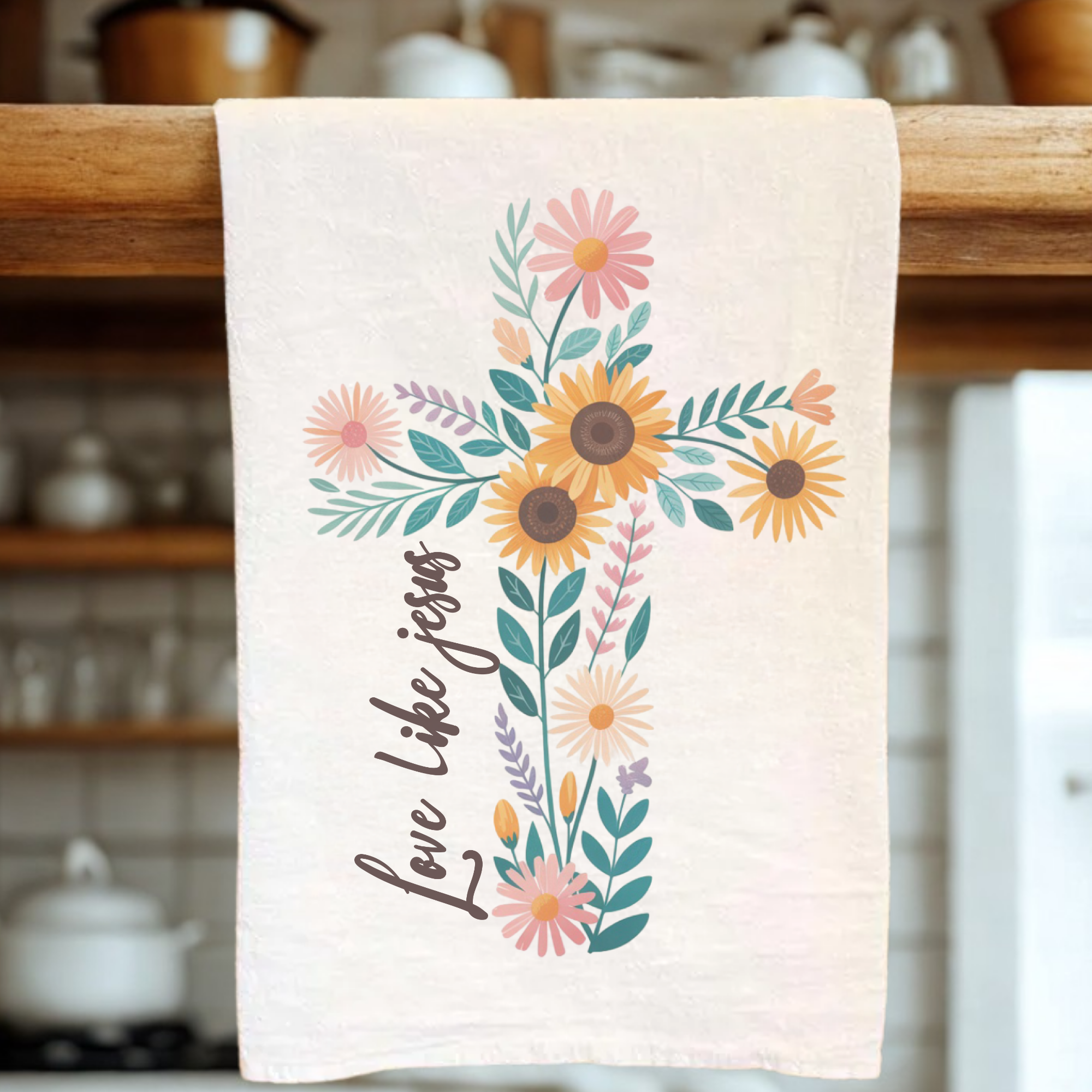 Floral designed tea towel with 'Love Like Jesus' text on a kitchen towel rack.