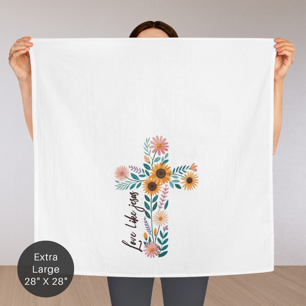Person holding an extra large white tea towel with a floral cross design and text.