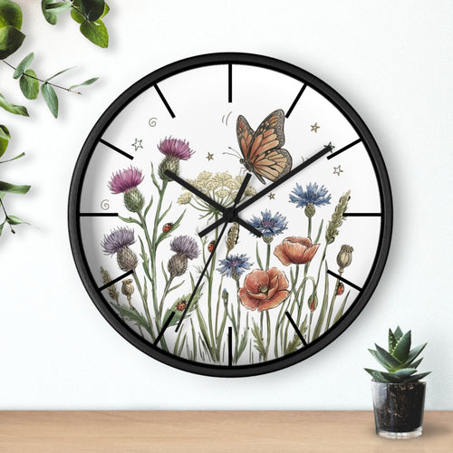 Round black decorative wall clock with floral and butterfly design on a white background