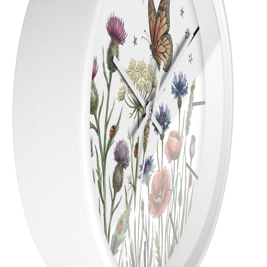 Sideview of a round white wall clock with white hands and floral and butterfly design on a white background