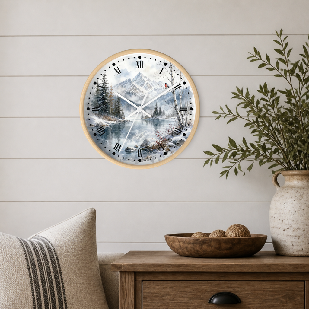 A round wall clock with a light wood frame and a scenic winter mountain landscape print, mounted on a white shiplap wall above a wooden side table with a plant and decorative bowl.