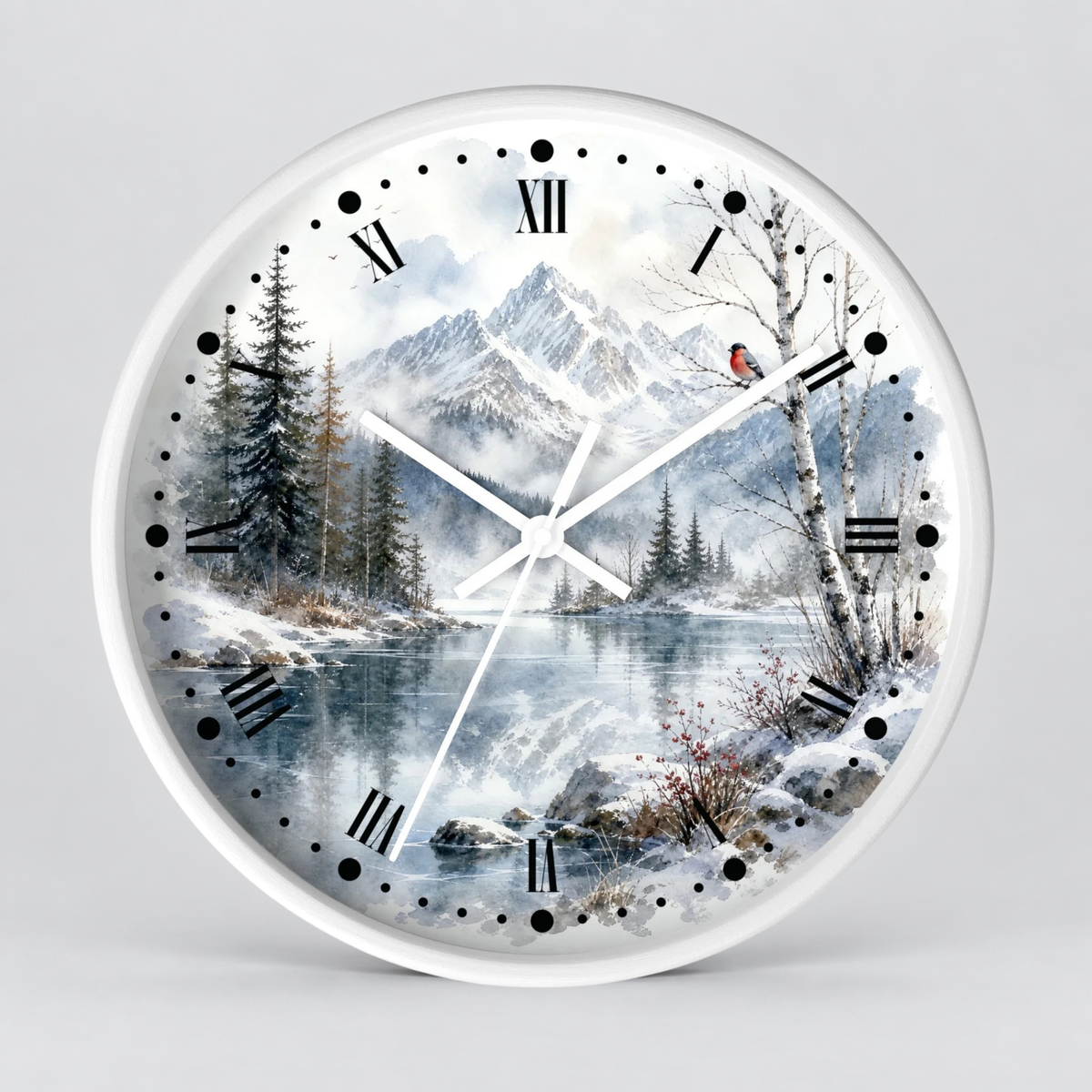 A round wall clock with a white frame and a winter landscape print on the face, featuring snow-covered mountains, a reflective lake, evergreen trees, bare birch trees, black Roman numerals, and white clock hands. A small red bird is perched on a tree branch near the upper right side of the dial.