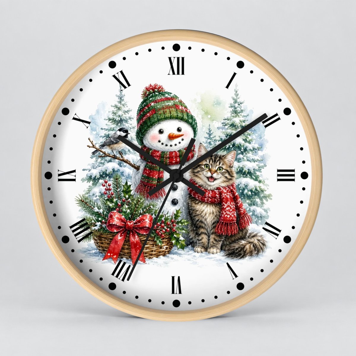 A round wall clock with a light wood frame and a white face featuring a winter holiday illustration of a snowman, a tabby cat, evergreen trees, and a basket of red berries. The clock has black Roman numerals and black hands, photographed against a neutral light gray background.