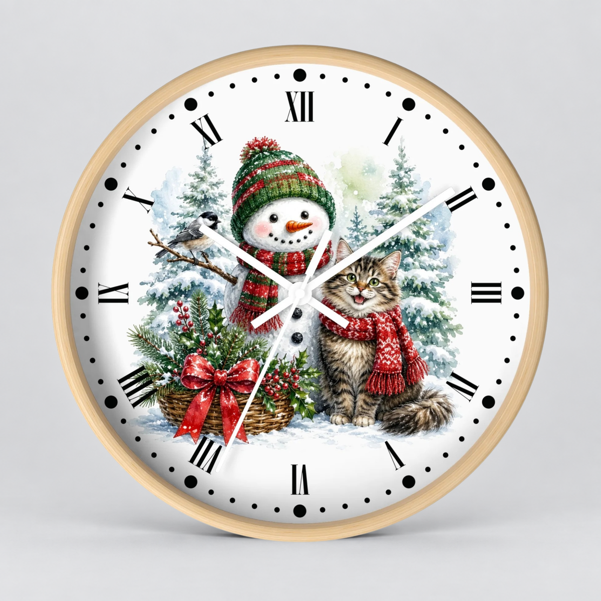 A round wall clock with a light wood frame and a white face featuring a festive Christmas illustration of a snowman and a cat wearing red scarves, surrounded by snowy trees and a basket of greenery. The clock has black Roman numerals and white hands on a light gray background.