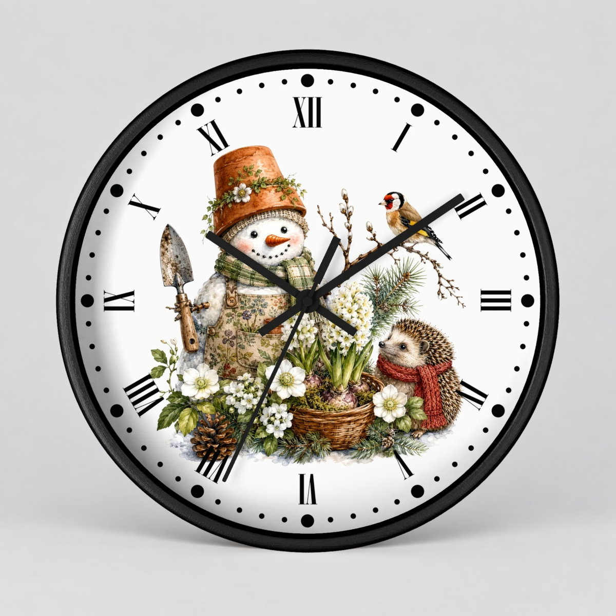 A round wall clock with a black frame and a white face featuring a winter garden illustration. The design includes a snowman in a flower hat, a hedgehog in a red scarf, a bird, flowers, pinecones, and Roman numeral hour markers.