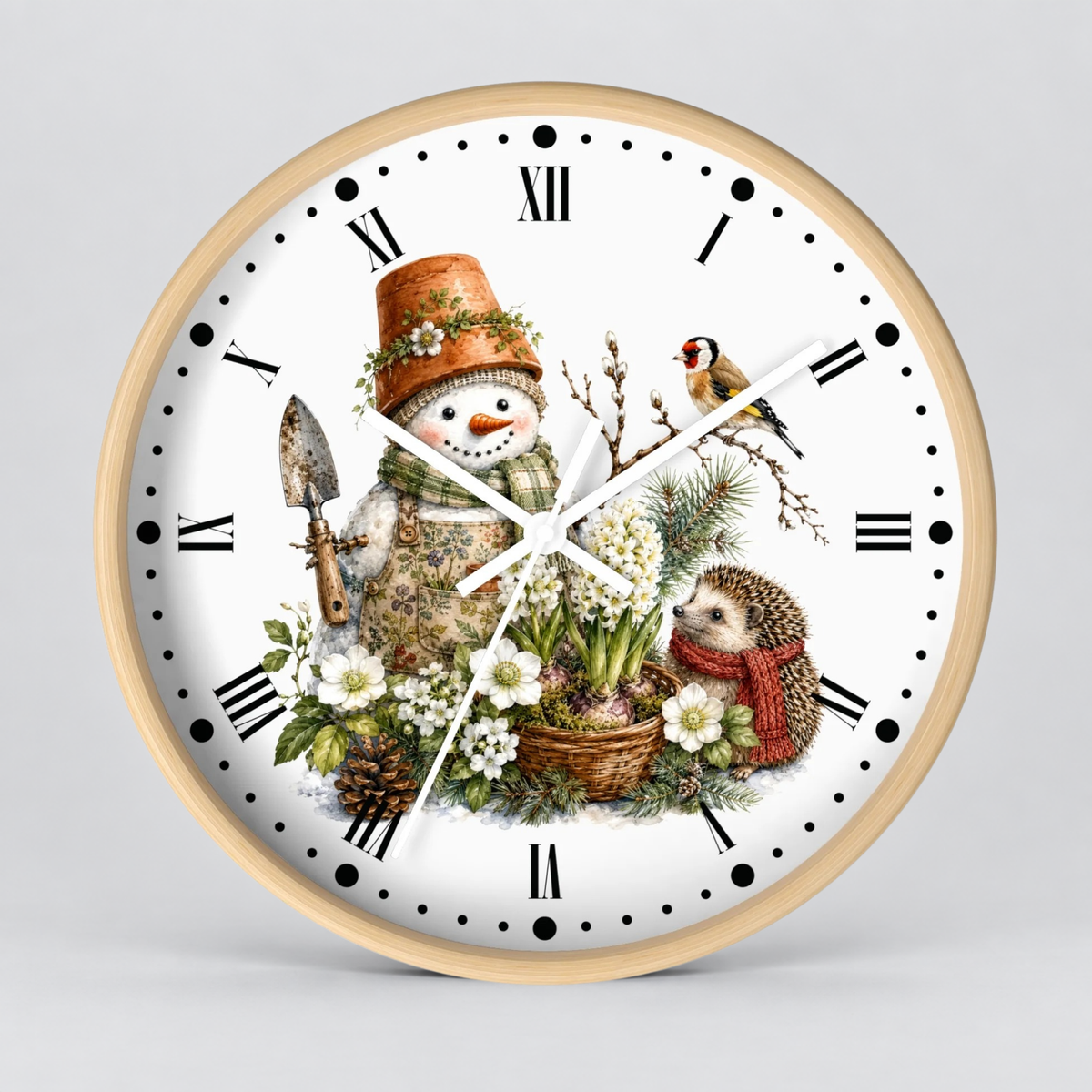 A round wall clock with a light natural wood frame and a white face, featuring a detailed winter illustration of a snowman, a hedgehog, a bird, flowers, and a small garden tool. The clock uses Roman numerals for hour markers and has black dot indices.
