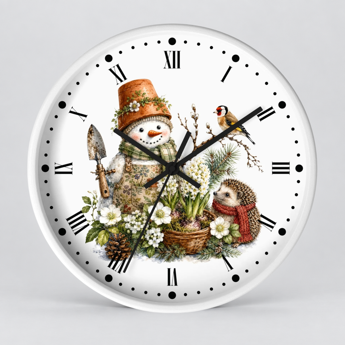 A round white wall clock with a vintage-style winter illustration on the face, featuring a snowman in a flower pot hat, a hedgehog in a red scarf, a bird, and floral elements. The clock has black Roman numerals and black hands and is photographed against a light gray background.