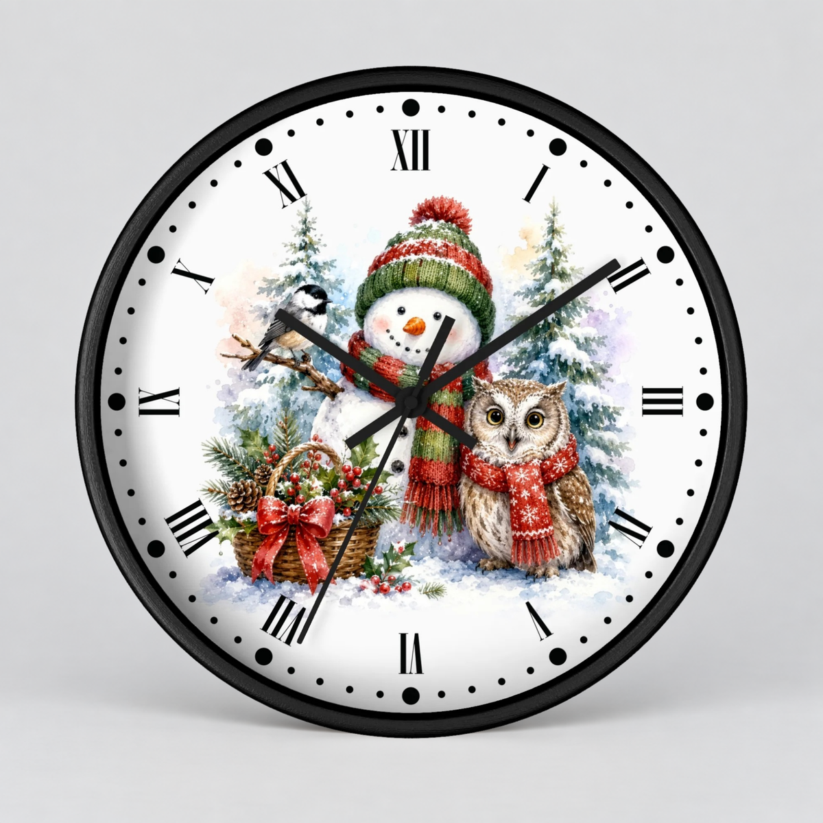 A round wall clock with a black frame and a white face featuring a winter holiday illustration of a snowman and an owl wearing red scarves and hats, with black Roman numerals and hands on a light gray background.