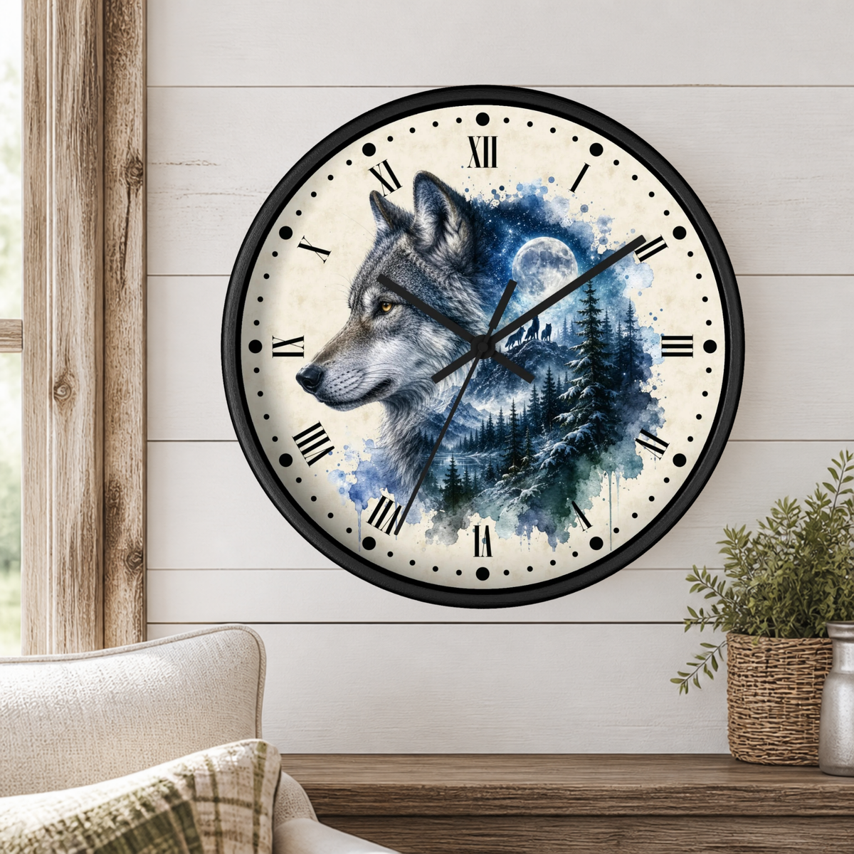 A round wall clock with a black frame and a watercolor-style wolf illustration in blue, white, and gray tones, mounted on a white shiplap wall above a wooden table with a plant and part of a chair visible.