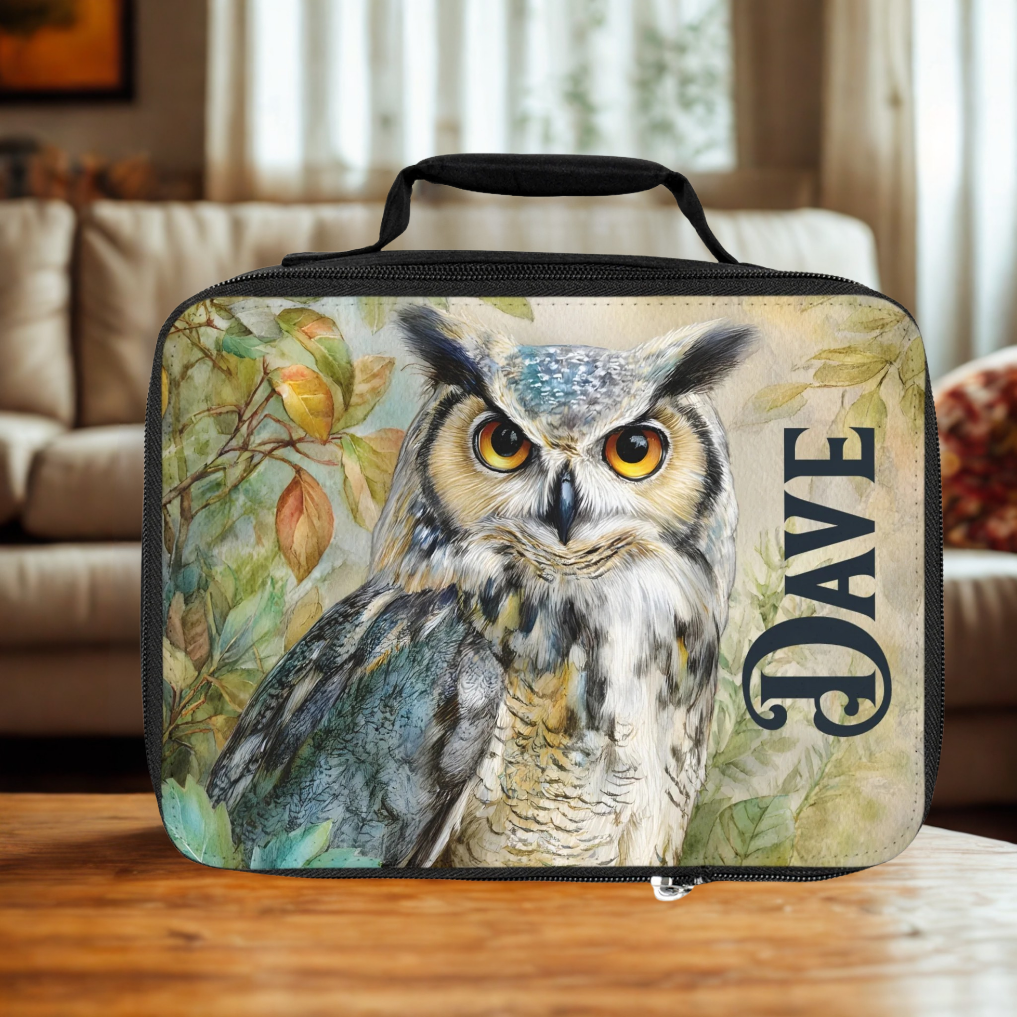 insulated lunch bag with an owl design and 'Dave' text on a wooden living room table.