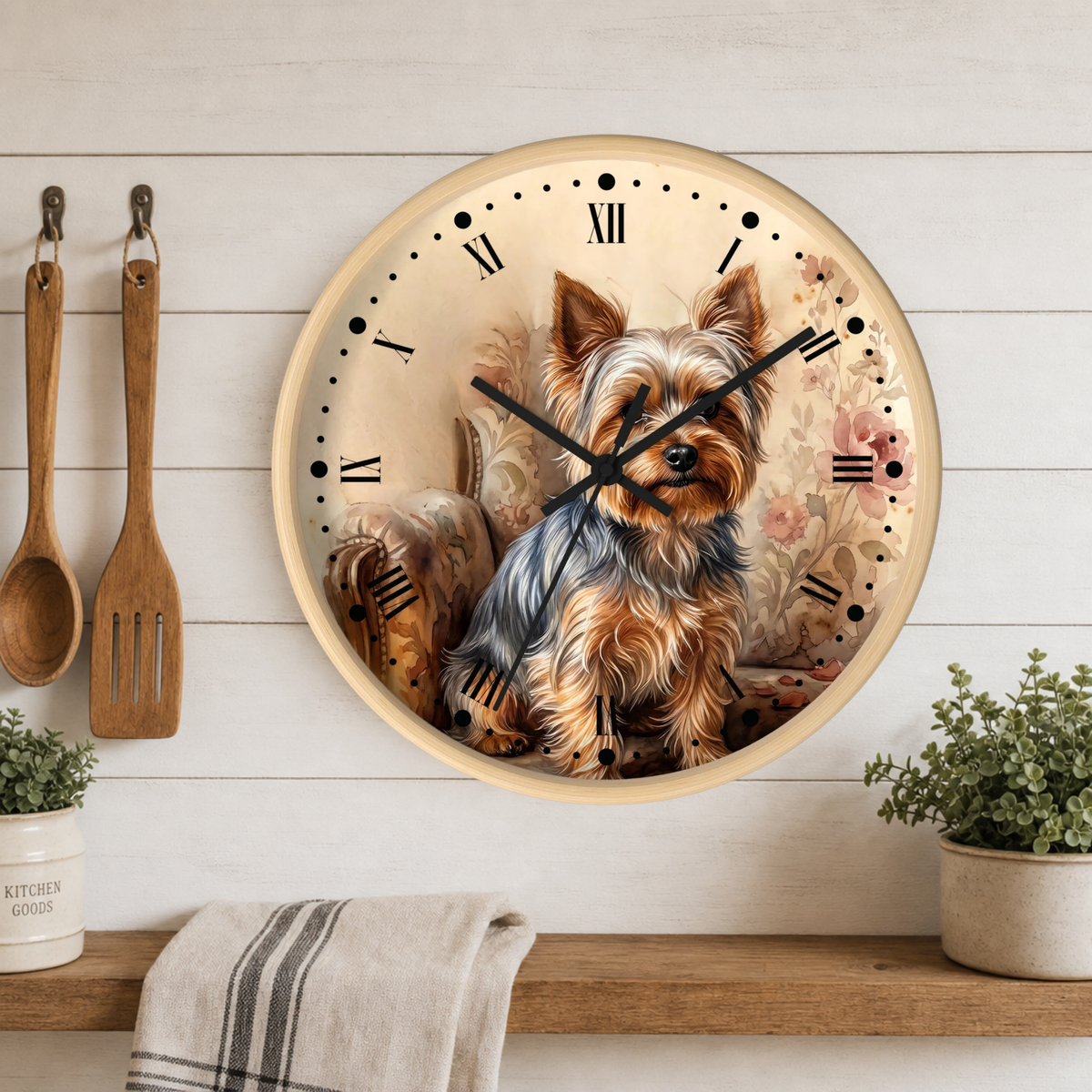 Round wall clock featuring a detailed illustration of a Yorkshire Terrier, styled on a white wood paneled wall above a wooden shelf with kitchen utensils and plants.