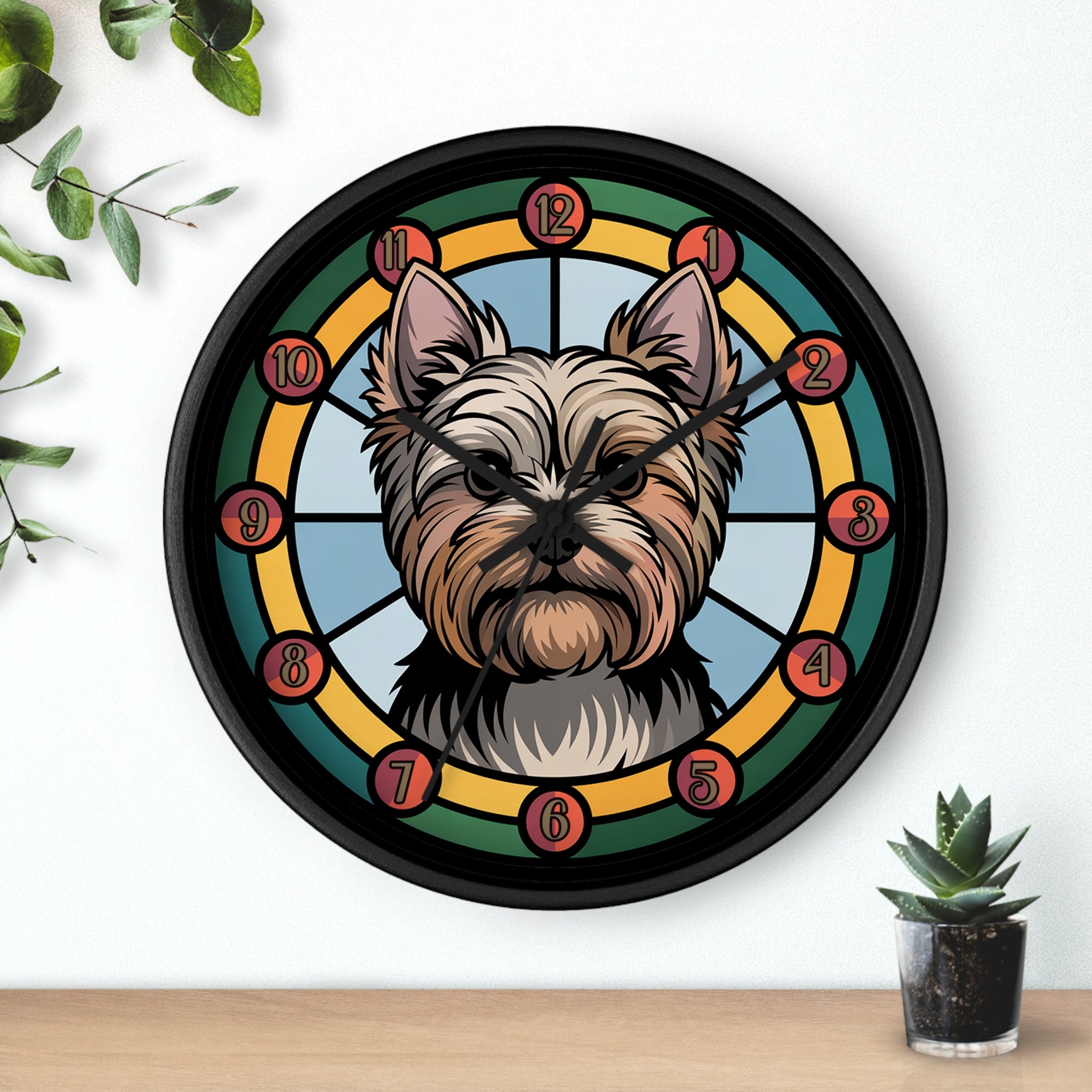 Round black wall clock with a Yorkie dog illustration on a white wall with plants.