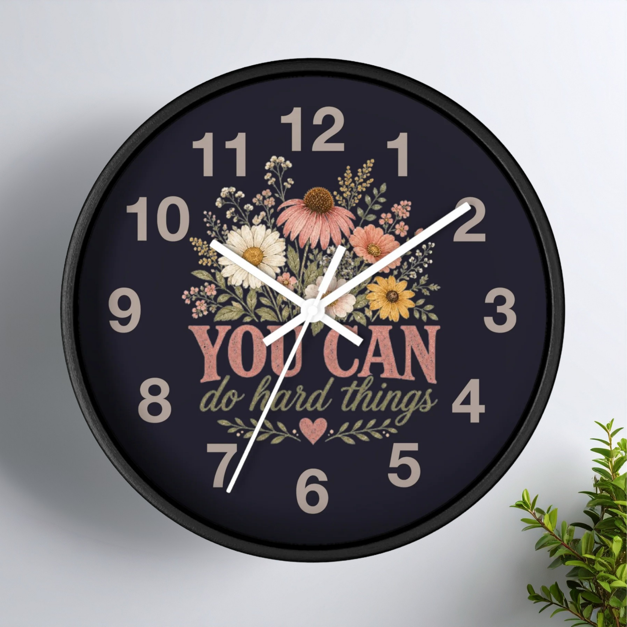 Decorative wall clock with floral design and motivational quote on a white background