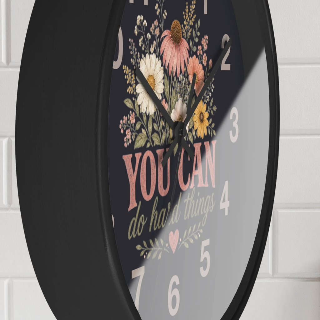 Decorative wall clock with floral design and motivational quote on a white brick wall background