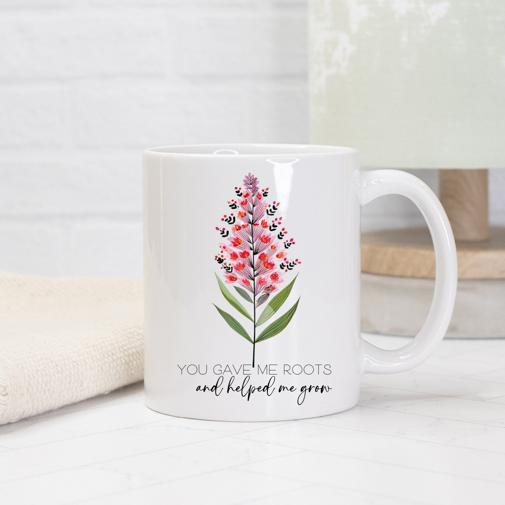 White 11oz mug with floral design and text on a light background