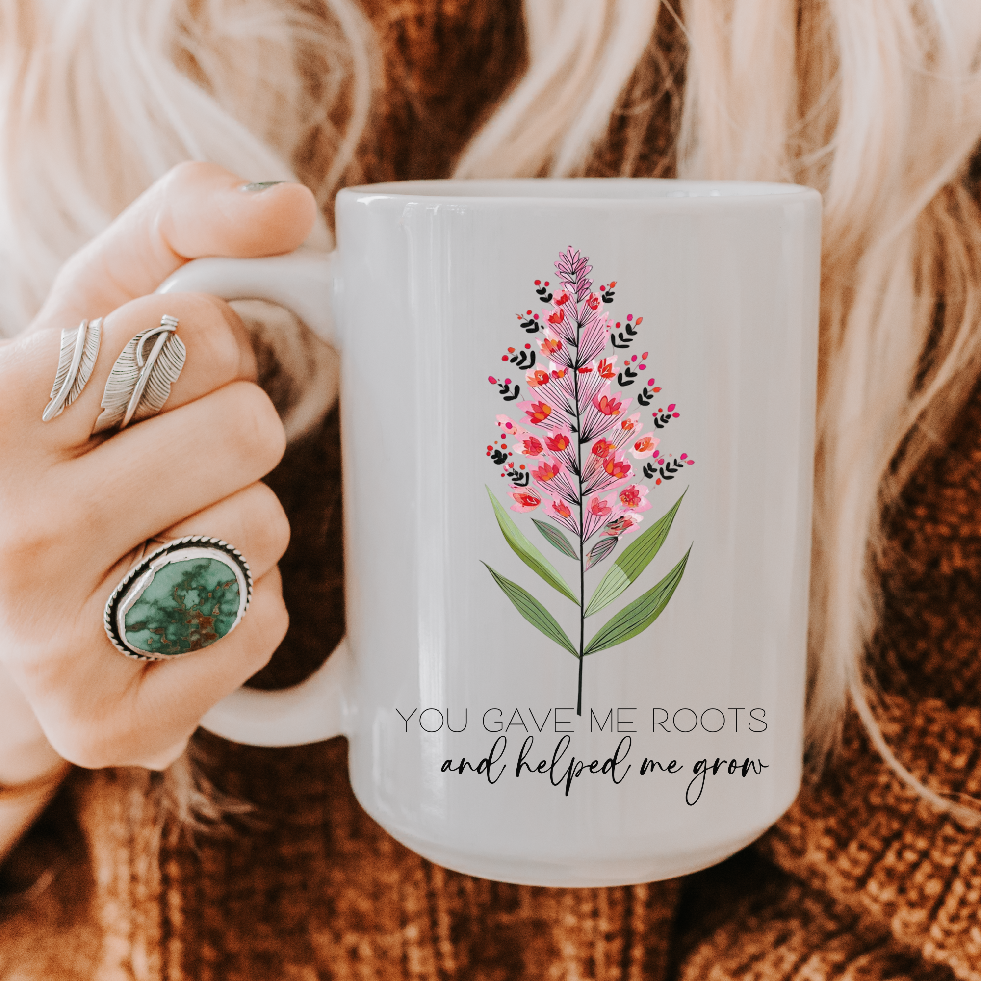 Person holding a 15oz mug with floral design and text 'You Gave Me Roots and Helped Me Grow'.
