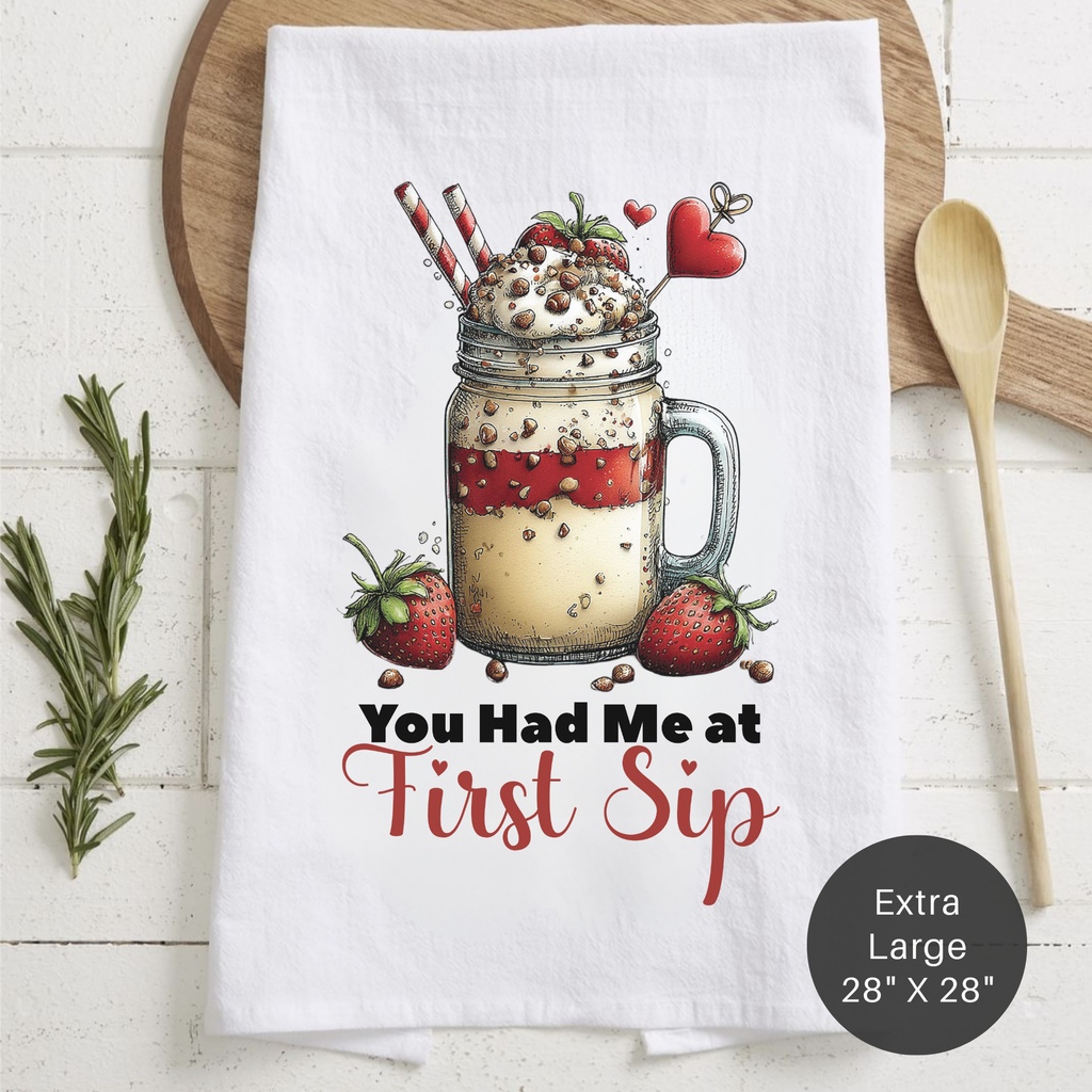 Tea towel with a mason jar design and text ' You Had Me At First Sip' on a wooden surface