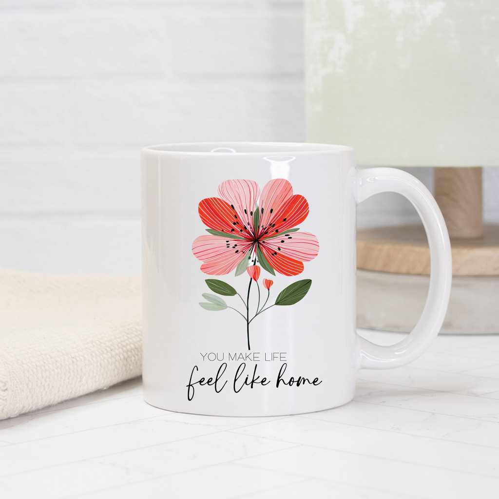 White 11oz. mug with a red floral design and text 'You make life feel like home' on a light background