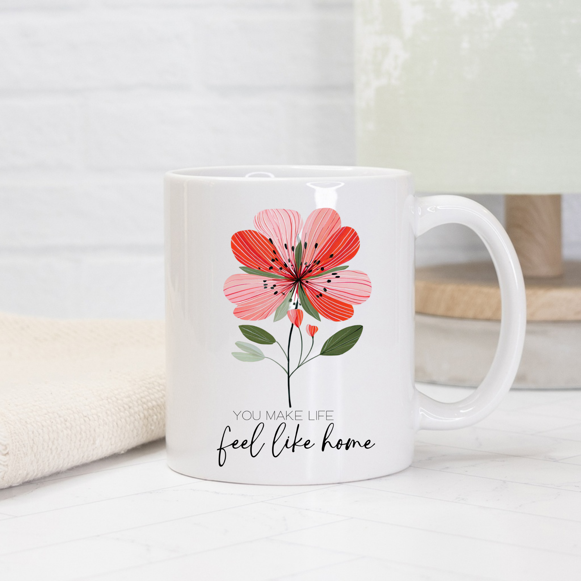 White 11oz. mug with a red floral design and text 'You make life feel like home' on a light background