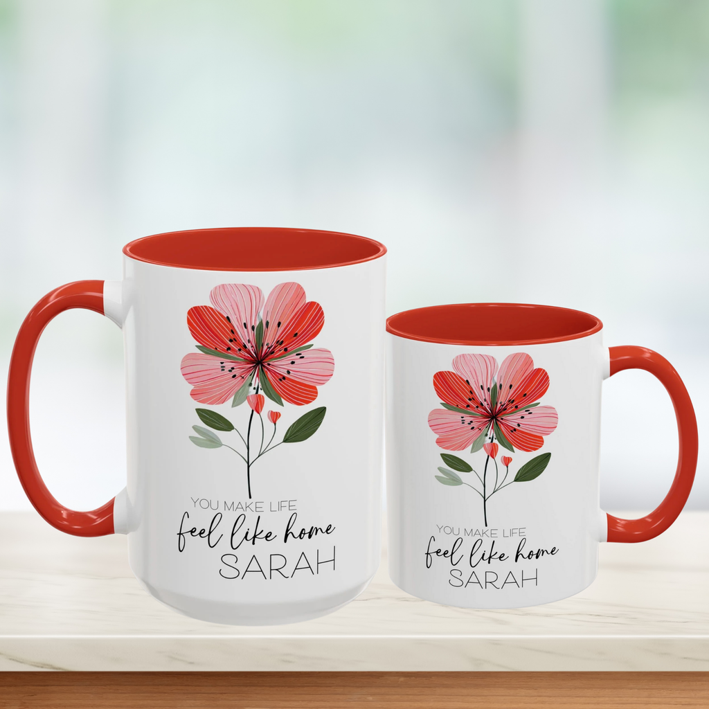 Two white mugs with red interior and handle, featuring floral design and personalized text 'You Make Life Feel Like Home'.
