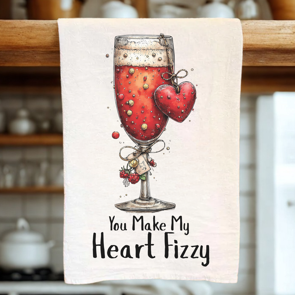 Towel with a glass of red wine and heart design, text 'You Make My Heart Fizzy' on a kitchen towel.