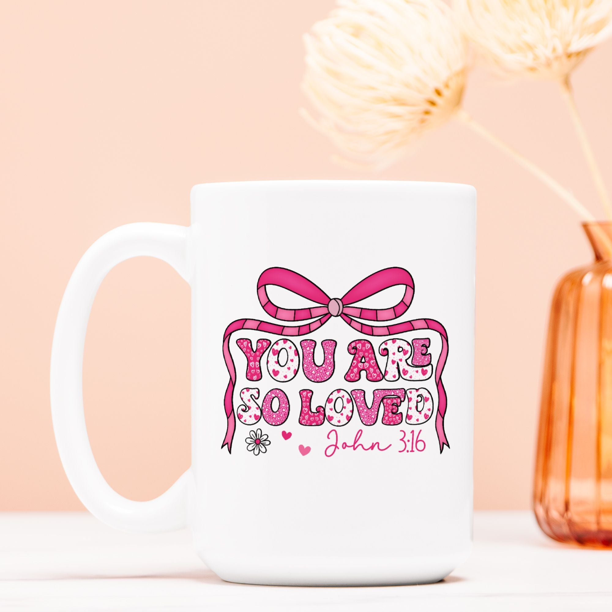 White mug with pink bow and text design on a light pink background