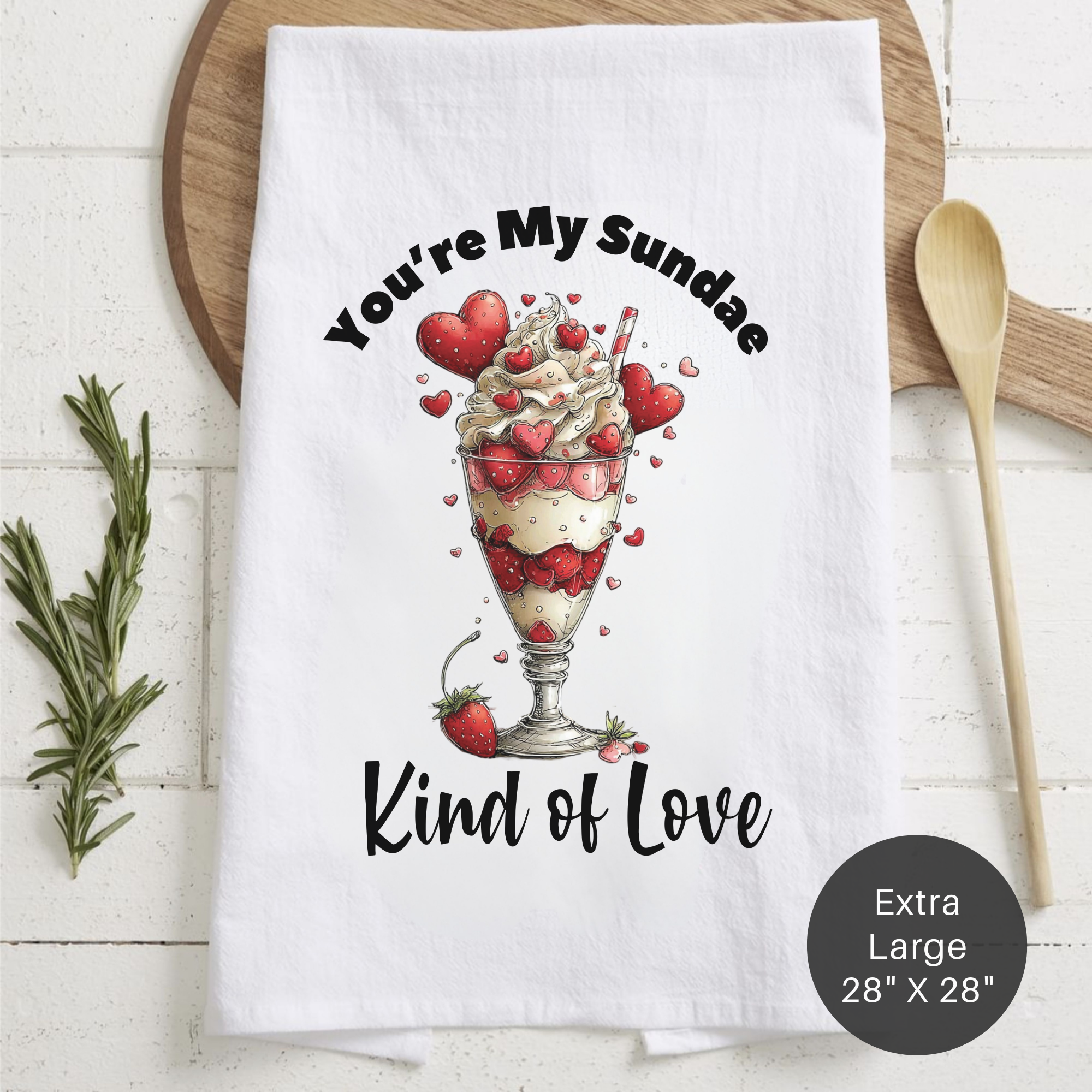 White tea towel with dessert graphic and text ' You're My Sundae Kind of Love' on a wooden surface