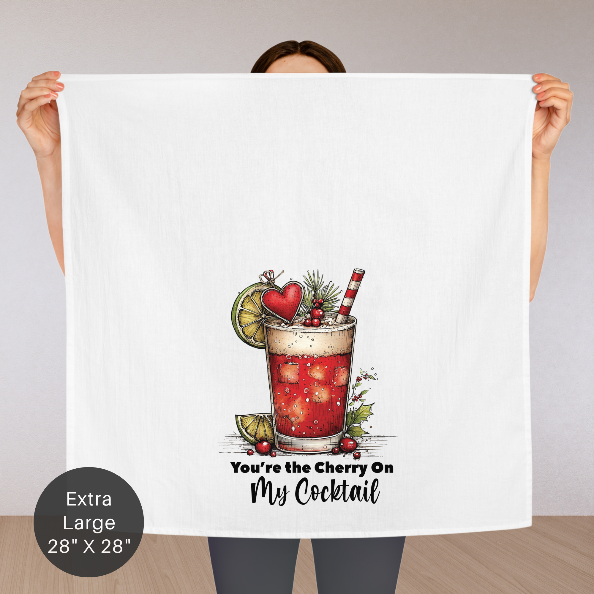Person holding an extra large tea towel with a cocktail illustration and text.