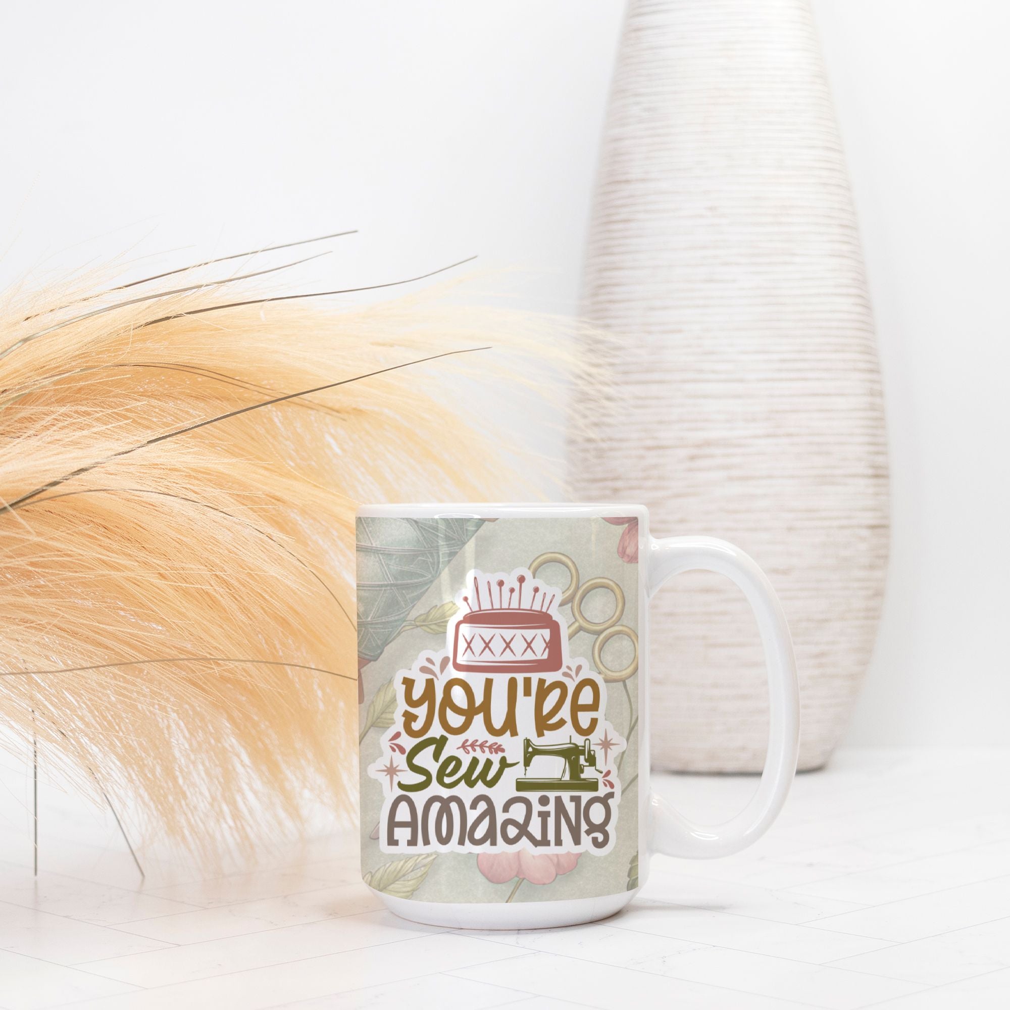 Mug with 'You're Sew Amazing' text on a white surface with decorative elements.