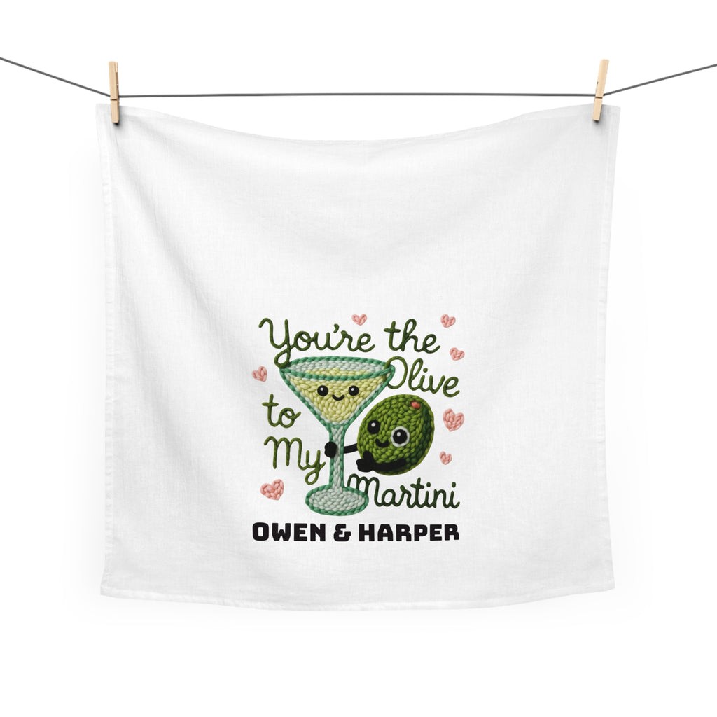 White towel with embroidered design of a martini glass and olive, text 'You're the Olive to My Martini' and brand name 'Owen & Harper'.