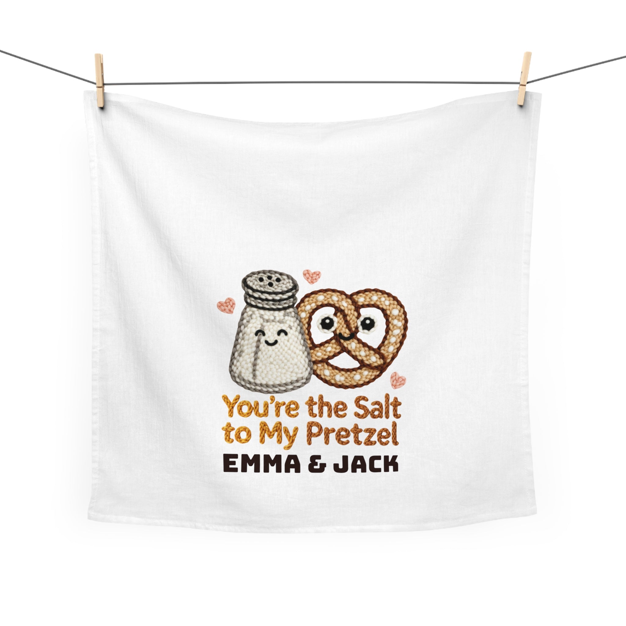 White towel with cartoon salt shaker and pretzel, text 'You're the Salt to My Pretzel' and 'Emma & Jack', hanging on a line.