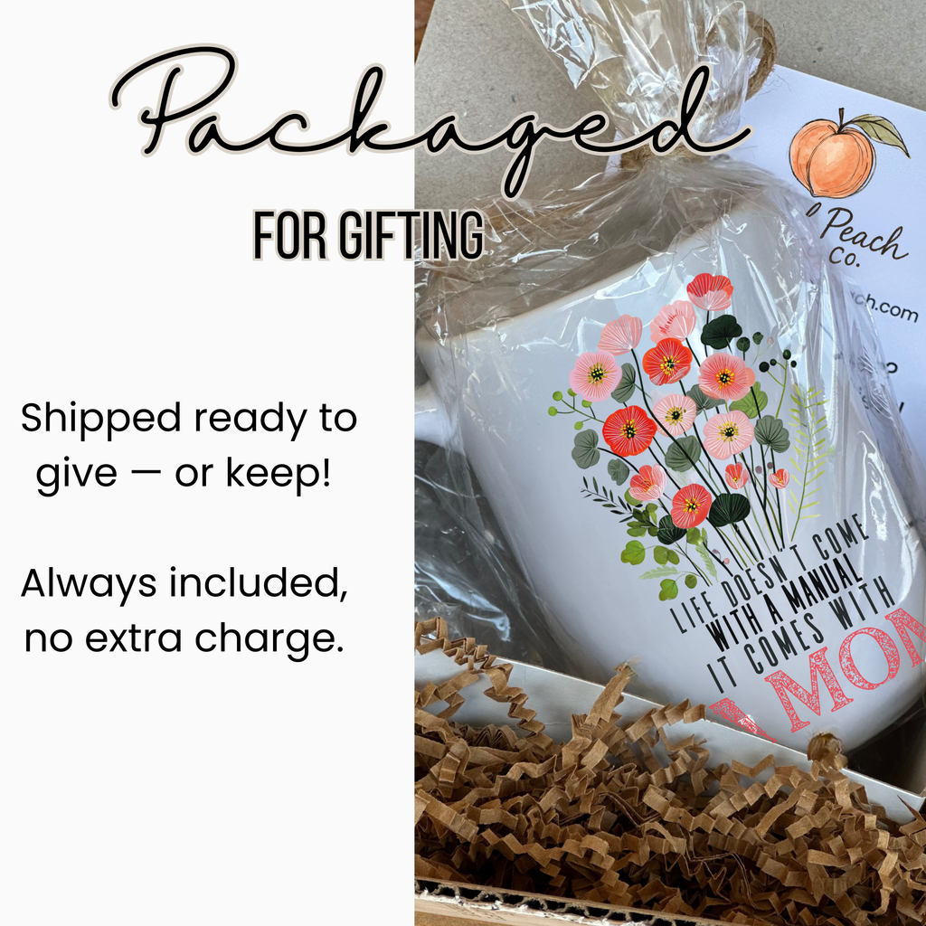 15oz white mug with floral design and text, wrapped in cellophane tied with twine in a white gift box with brown paper underneath.