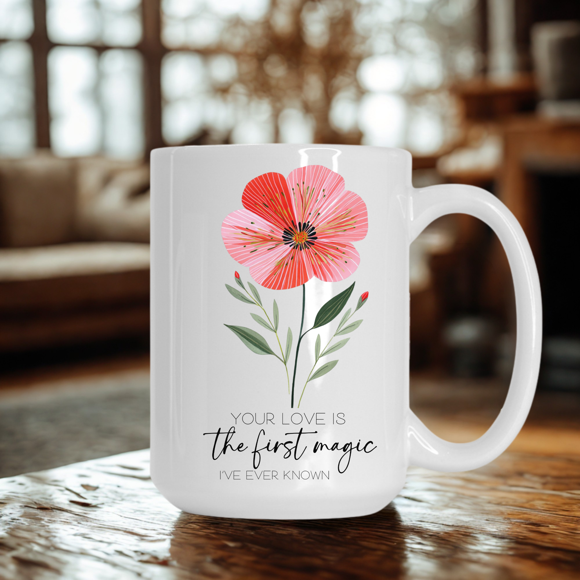 15oz white mug with a pink floral design and text 'Your Love Is the first magic I've Ever Known' on a wooden table.
