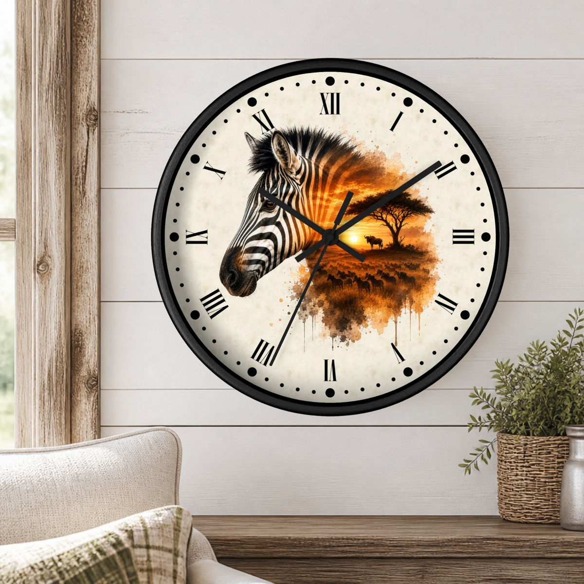 A round wall clock with a black frame and a zebra head illustration over an orange sunset landscape, mounted on a white shiplap wall above a wooden table with a plant.