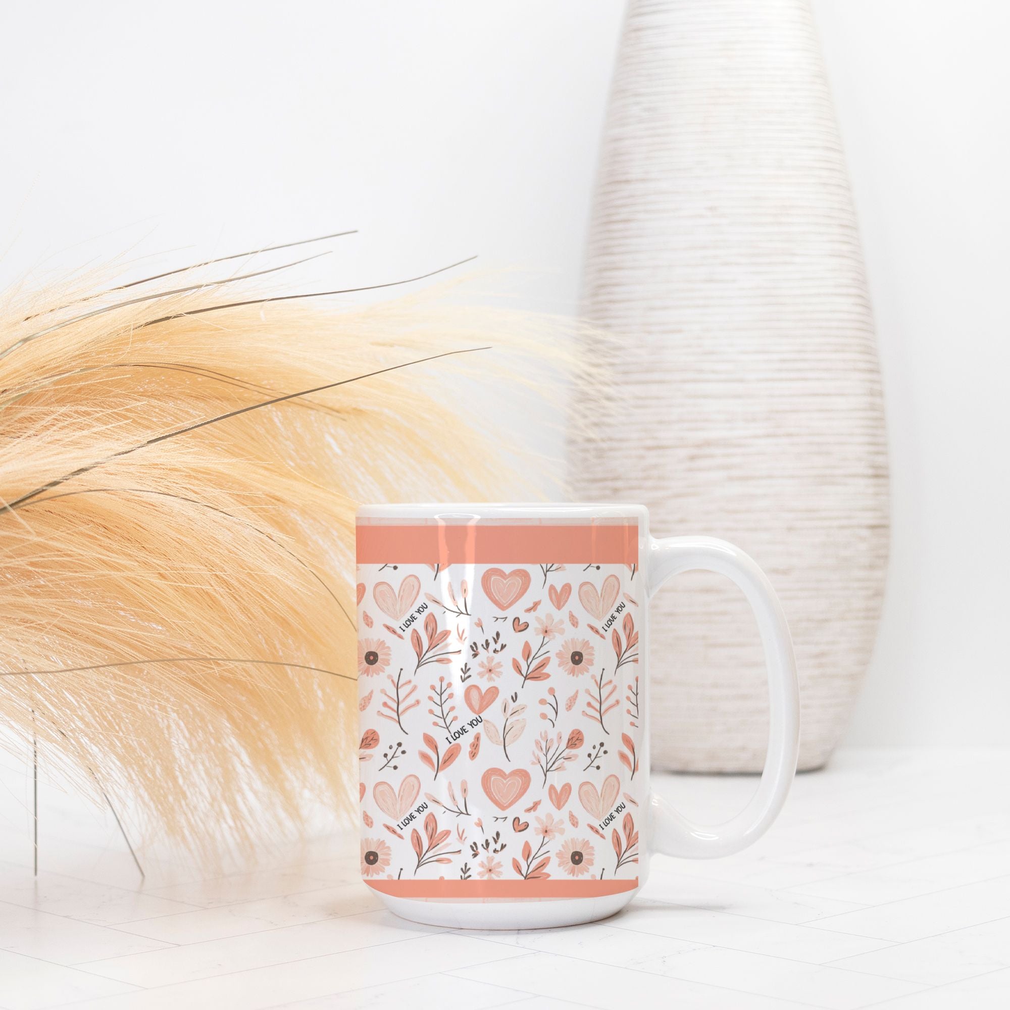 White mug with floral and heart pattern on a white surface with decorative elements