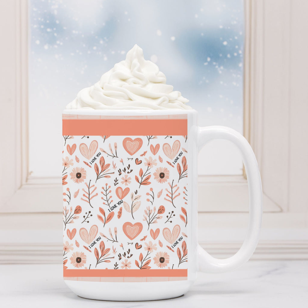 White mug with floral pattern and 'I love you' text, filled with hot chocolate and whipped cream.