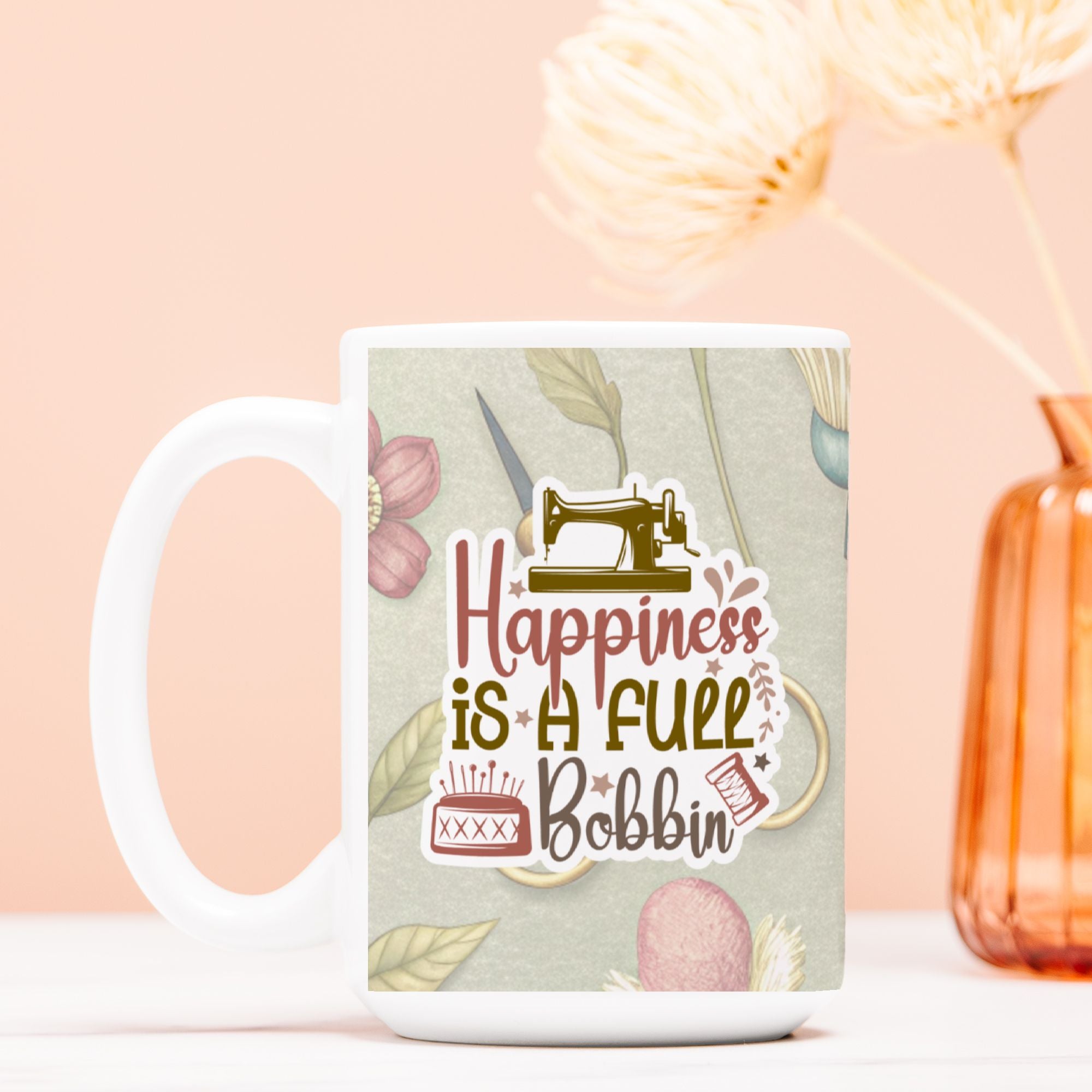 Mug with sewing-themed design and text 'Happiness is a Full Bobbin' on a light background