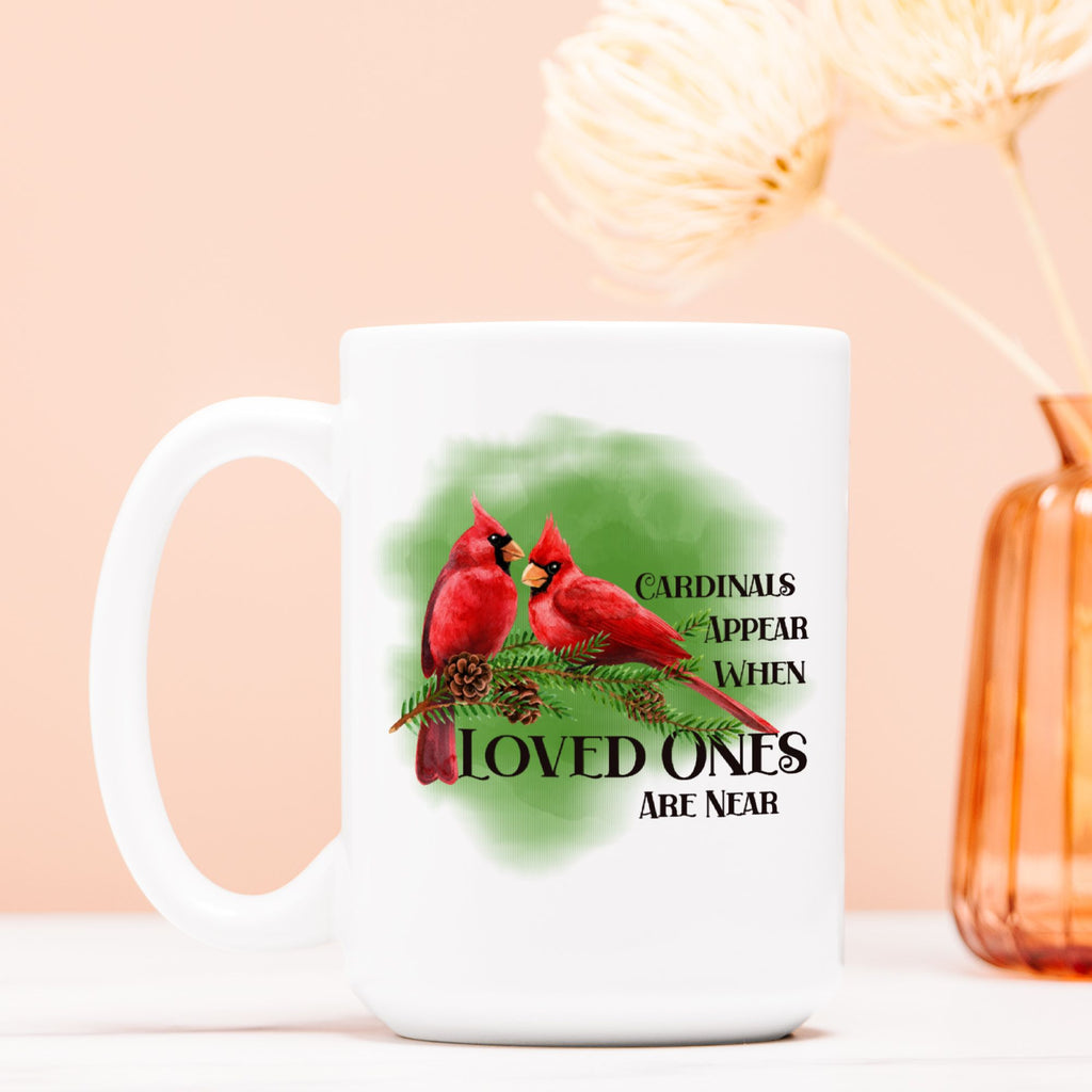 White mug with red cardinals and text on a light pink background