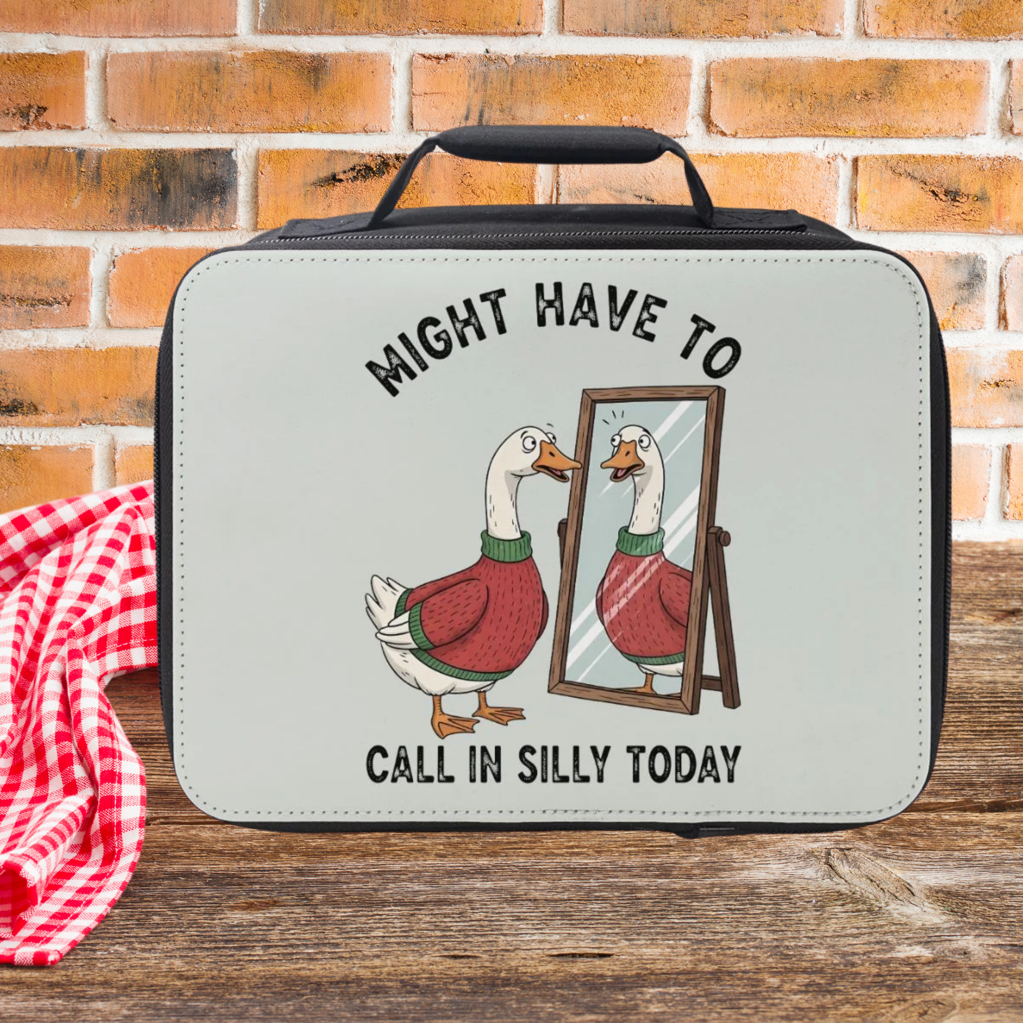 Lunch bag with a cartoon duck and humorous text on a brick wall background