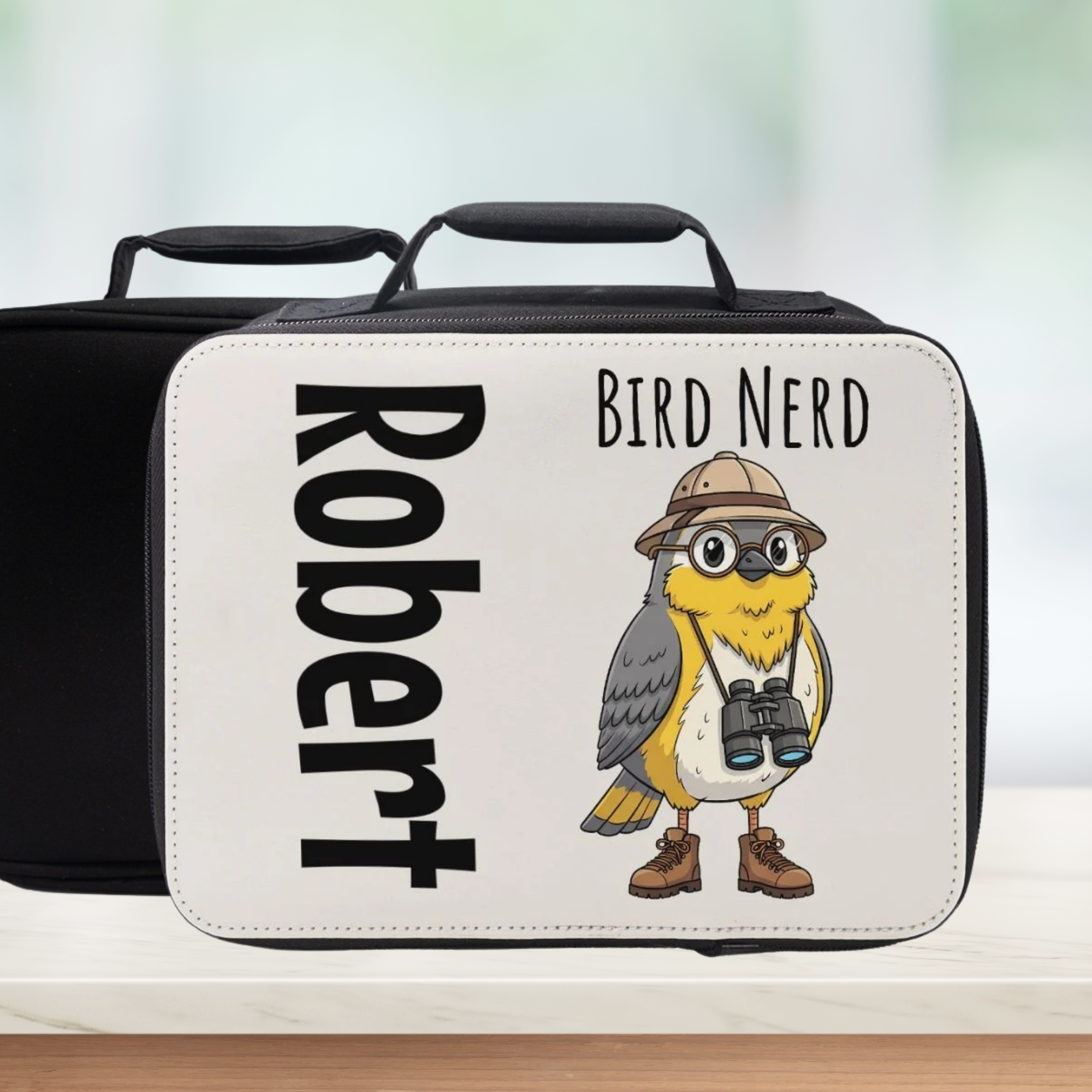 Personalized lunch box with bird illustration and text on a blurred background